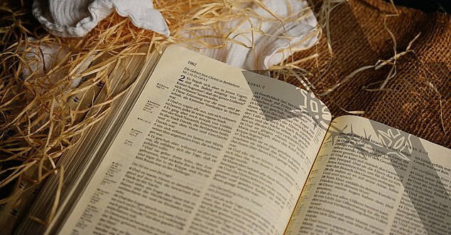 Bibel mit Evangelium nach Lukas auf Stroh